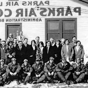 Students, faculty and staff pose in front of the main administrative building.